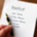 a handwritten list of five candidates on paper, with the hand holding an expensive fountai