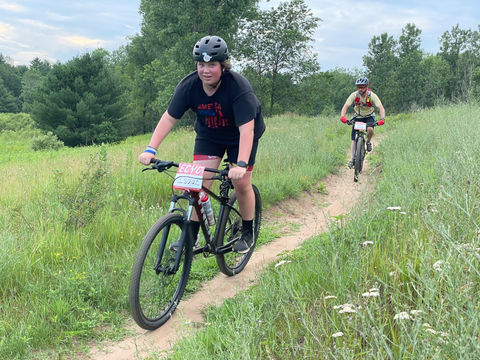 mountain bikers on trail in field