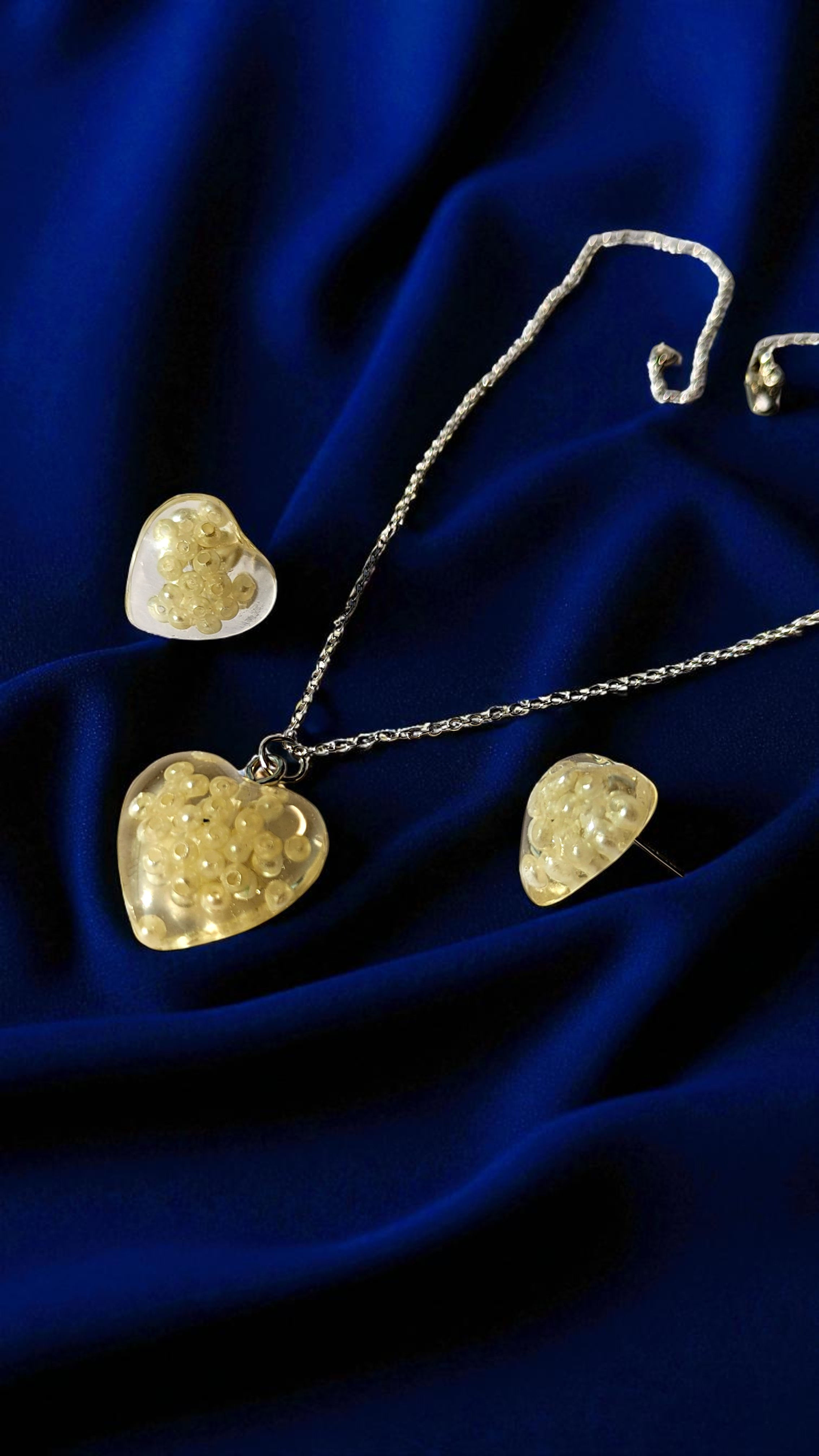 Close-up view of heart pendant necklace with matching earrings for women