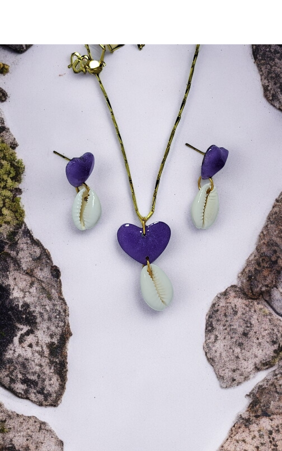 Purple glitter heart-shaped jewelry set featuring a necklace and dangle earrings, each adorned with a natural cowrie shell.
