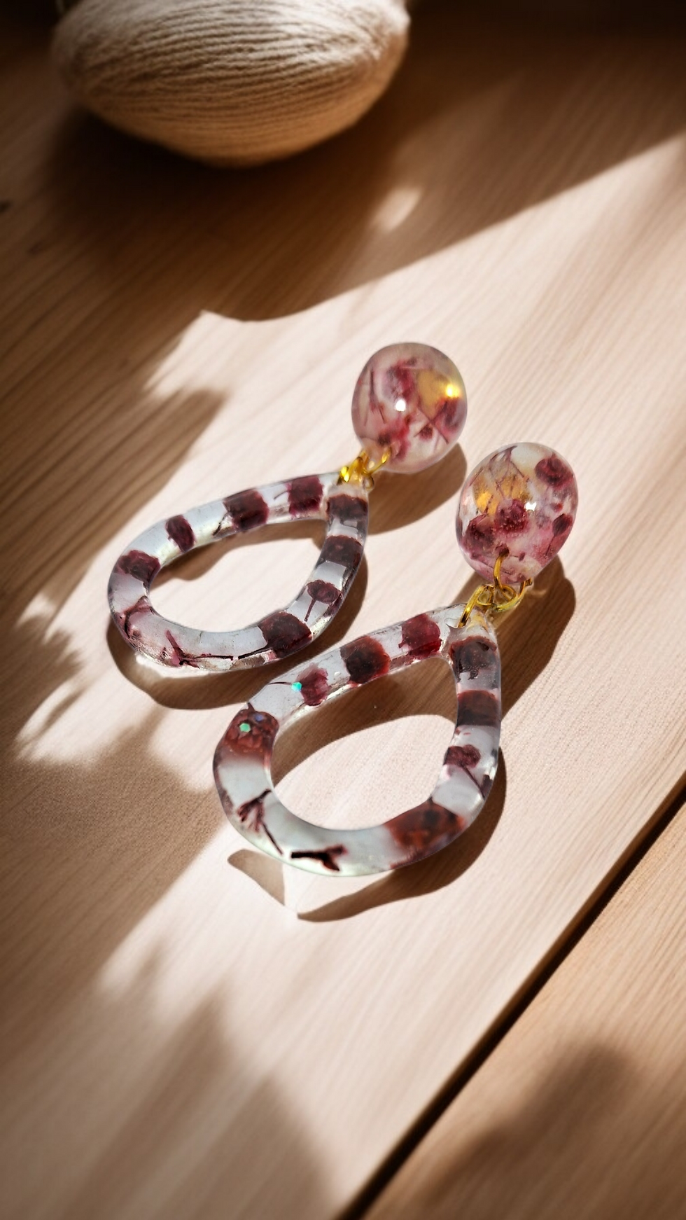 Pair of handmade clear teardrop earrings with real pressed pink and red wildflowers, a unique gift for nature lovers.