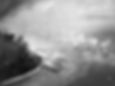 Aerial view of landing craft approaching a smoke-covered beach with ocean backdrop. Numerous boats create wakes; scene is tense and warlike.