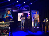 Magician performing a live mentalism act on stage with audience participants at The Space theater.
