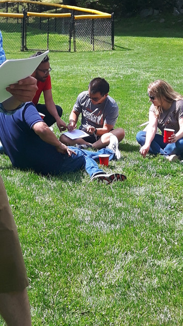 A group of retirees engaging in various outdoor activities such as lawn games, walking, or picnicking in a scenic outdoor setting, enjoying the fresh air and camaraderie during the retirement party celebration.