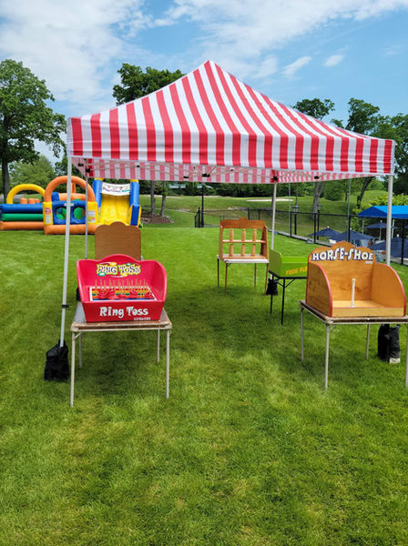 Outdoor carnival Ring Toss and Hoop Shot games under a red striped tent provided by Magical Memories Entertainment.