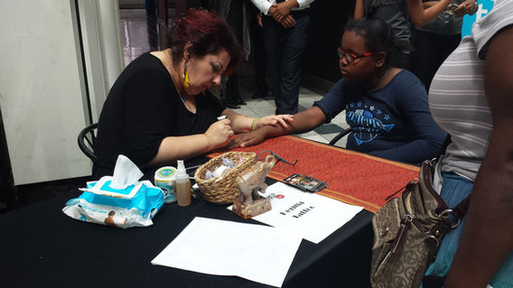 Henna artist serving guests at an event table