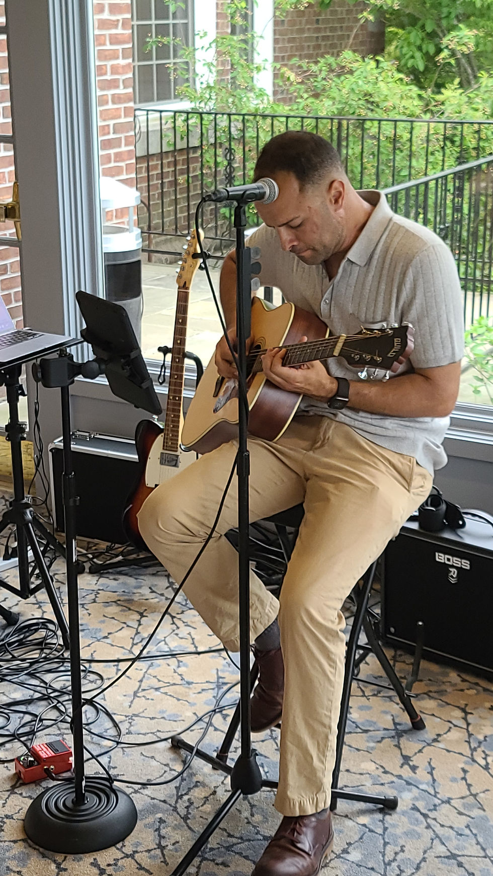 Acoustic guitar and microphone setup with sound equipment prepared for a live music performance.