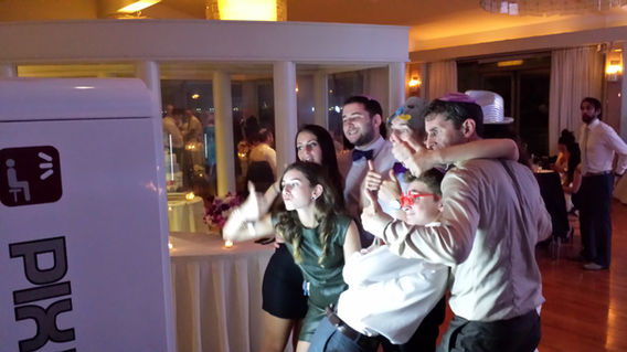 Guests using an open air photo booth at a party