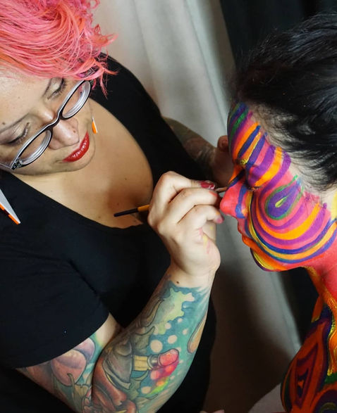 Artist creating live body painting design at an event