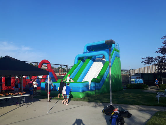 Inflatable bounce house providing endless fun at the grand opening, attracting children with its vibrant colors and exciting activities.