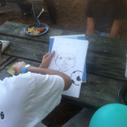 Child drawing a soccer-themed portrait at a golden hour outdoor event