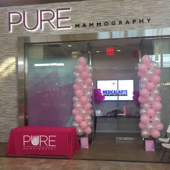 Pink and white decorative balloon columns framing the entrance of a medical office for a grand opening Product Launch.