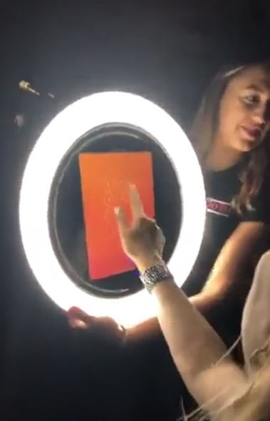 Roaming photo booth ring light illuminating a guest while taking a photo