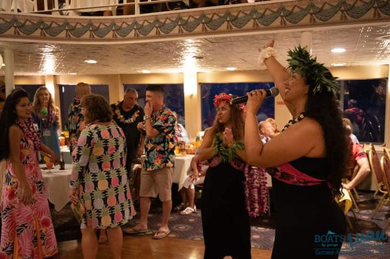 A hula performer demonstrating a traditional dance, captivating the audience with fluid movements and expressive storytelling through graceful gestures and rhythmic swaying.