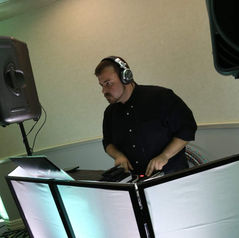 DJ performing at a private event with headphones and mixing equipment.