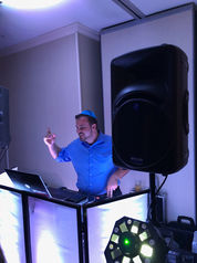 Magical Memories Entertainment DJ performing live at an indoor event with lighting and sound setup.