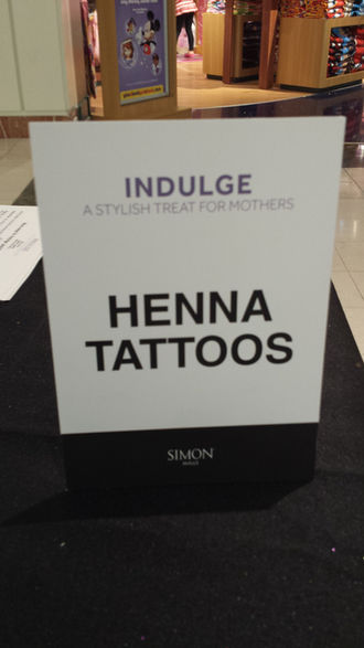 Henna tattoos sign displayed at an event