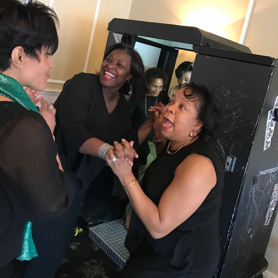 Group of guests using an enclosed photo booth