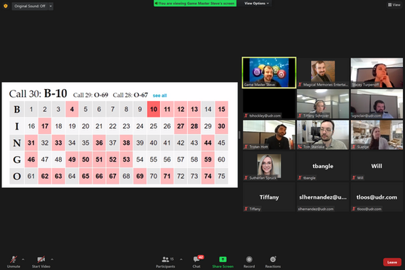 Screenshot of a Zoom meeting showing a virtual bingo board with numbers called, the game host highlighted, and multiple participants smiling and watching the game.