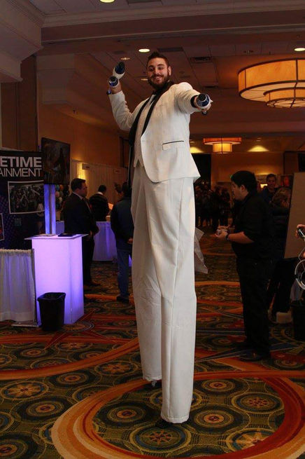 An MME stilt walker entertains attendees at the event, towering above the crowd in vibrant attire, adding a touch of whimsy and excitement to the atmosphere.