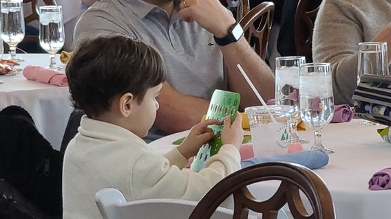 Child playing bingo at a table during an indoor event hosted by Magical Memories Entertainment