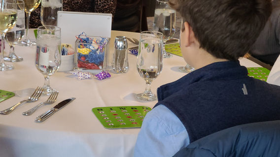 Child enjoying a Bingo game using a green card at a client event featuring entertainment by Magical Memories Entertainment.