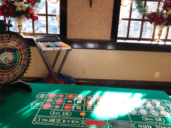 Roulette table and wheel from Magical Memories Entertainment set up indoors for a casino themed party
