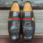 Classic Gucci black leather loafers with signature green and red web stripe, deeply conditioned and