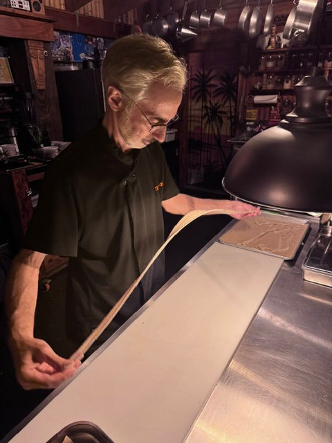 Chef Ernie hand pulling biang biang noodles made with tomatillo husk water
