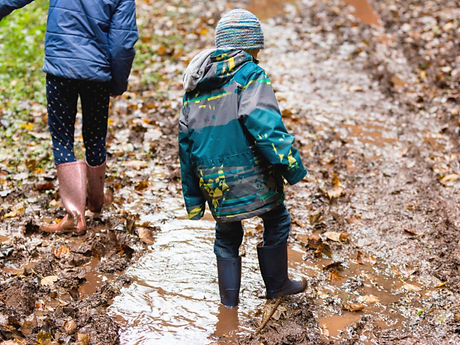 Two children wearing wellies walking through deep mud_edited.jpg