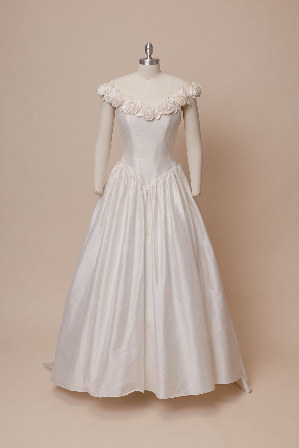 Thumbnail: 1990s vintage Catherine Rayner wedding dress with rosette neckline on mannequin against ivory backdrop