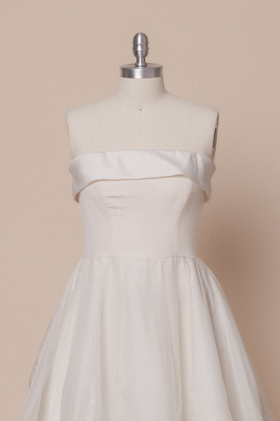 Strapless vintage silk Carolina Herrera wedding dress with stripes on mannequin against ivory backdrop