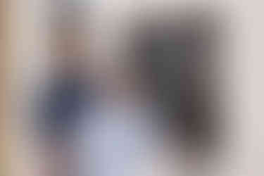 An engagement photo of a couple in blue in front of the doors of the Oaks Pioneer Church in Portland