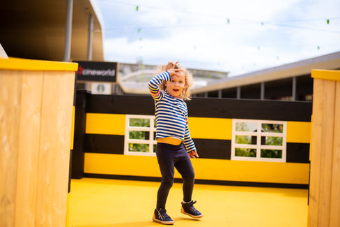 Kid dancing out of happiness in the Honey Bee Maze, an event by Kit and Caboodle, Architects of Happiness.