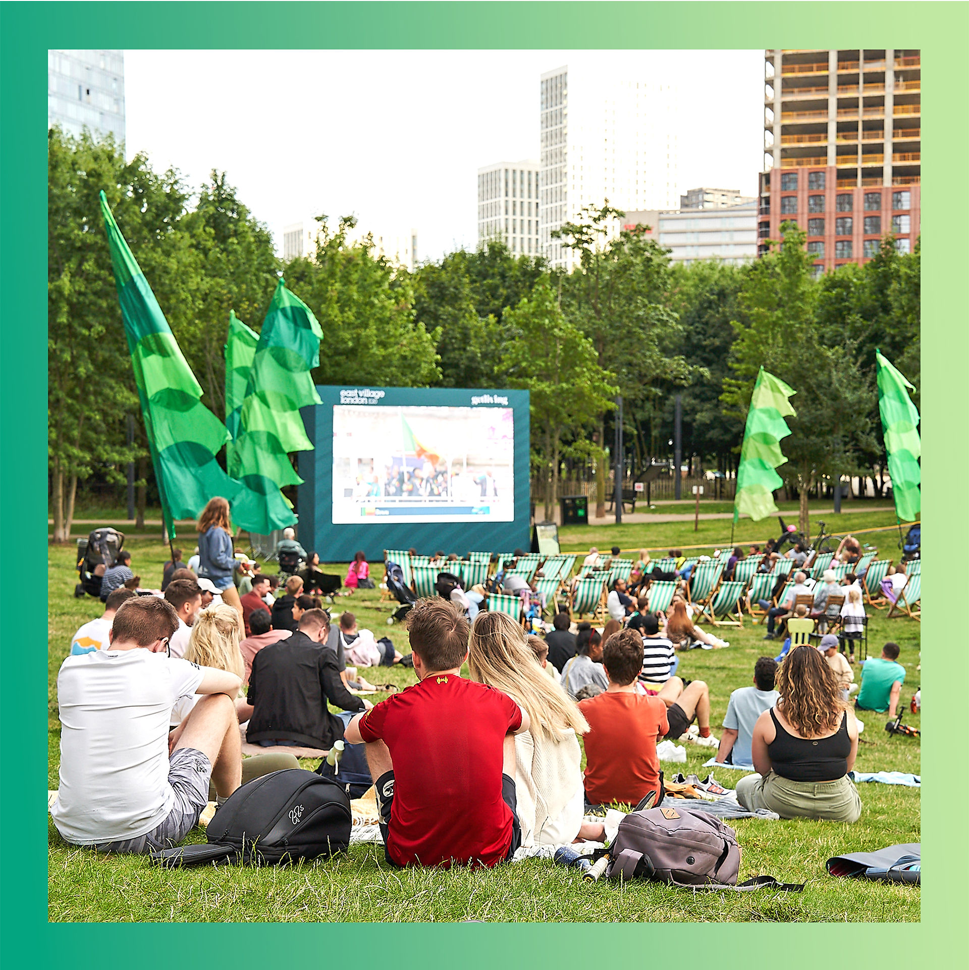 Crowds gathered around a large outdoor screen in Victory Park East Village.