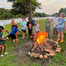campers roast marshmallows on the fire