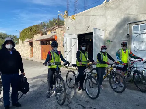 Grupo de ciclistas con chalecos amarillos posan para la fotografía en la calle.