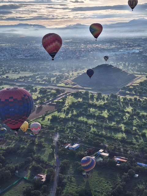 Globos aerostáticos sobre Teotihuacán, cielo nublado con montañas, Vuelos en globo.