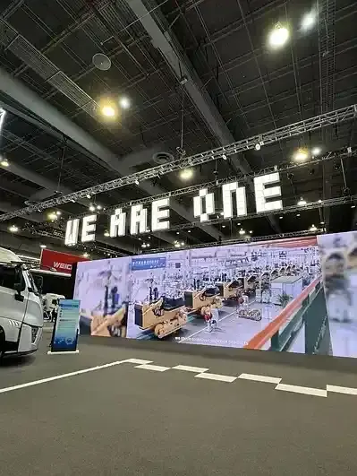 Letrero grande Letras volumétricas "WE ARE ONE" en exposición de vehículos.