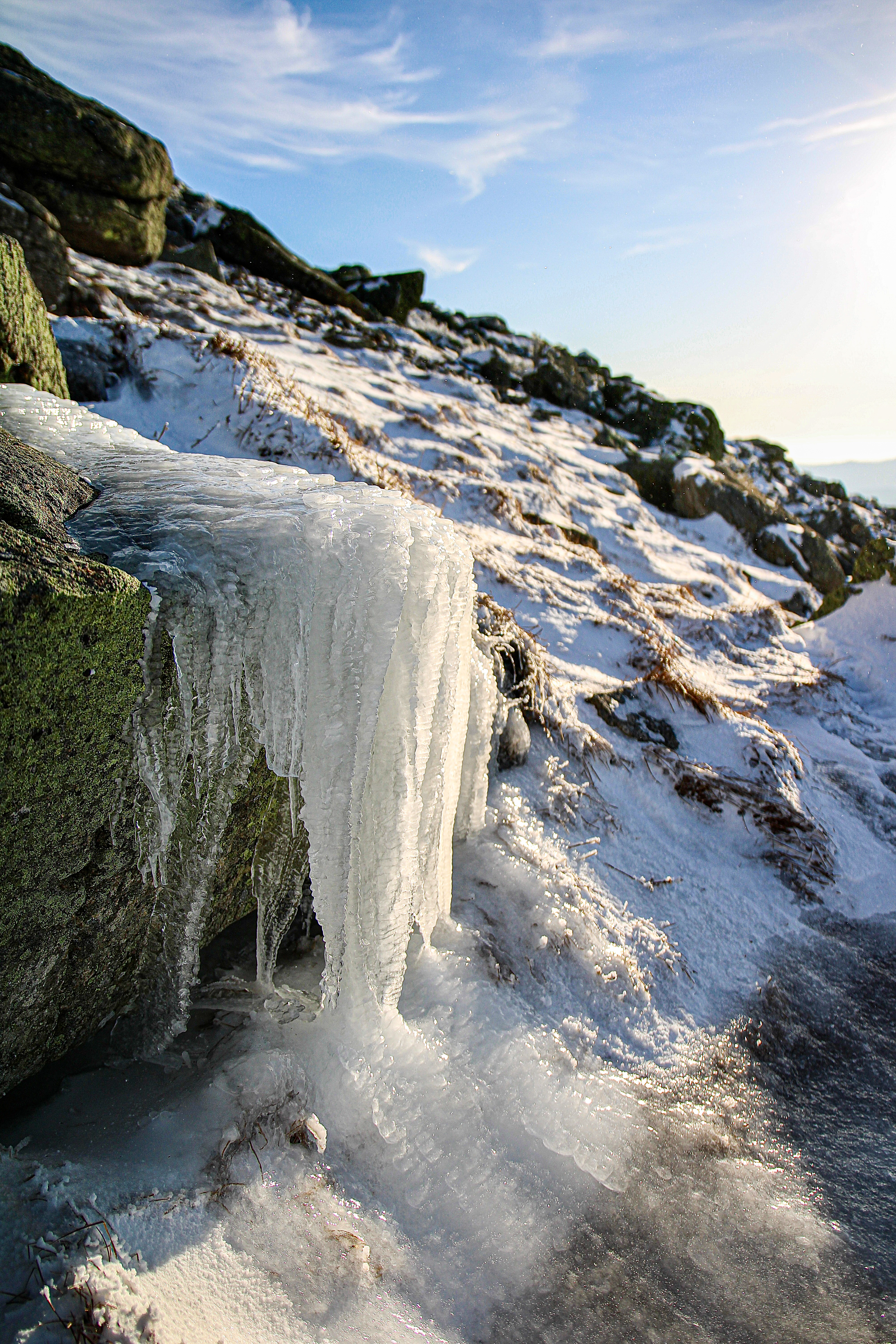 Sunlit icicles hanging from a rocky ledge near Mount Lafayette.