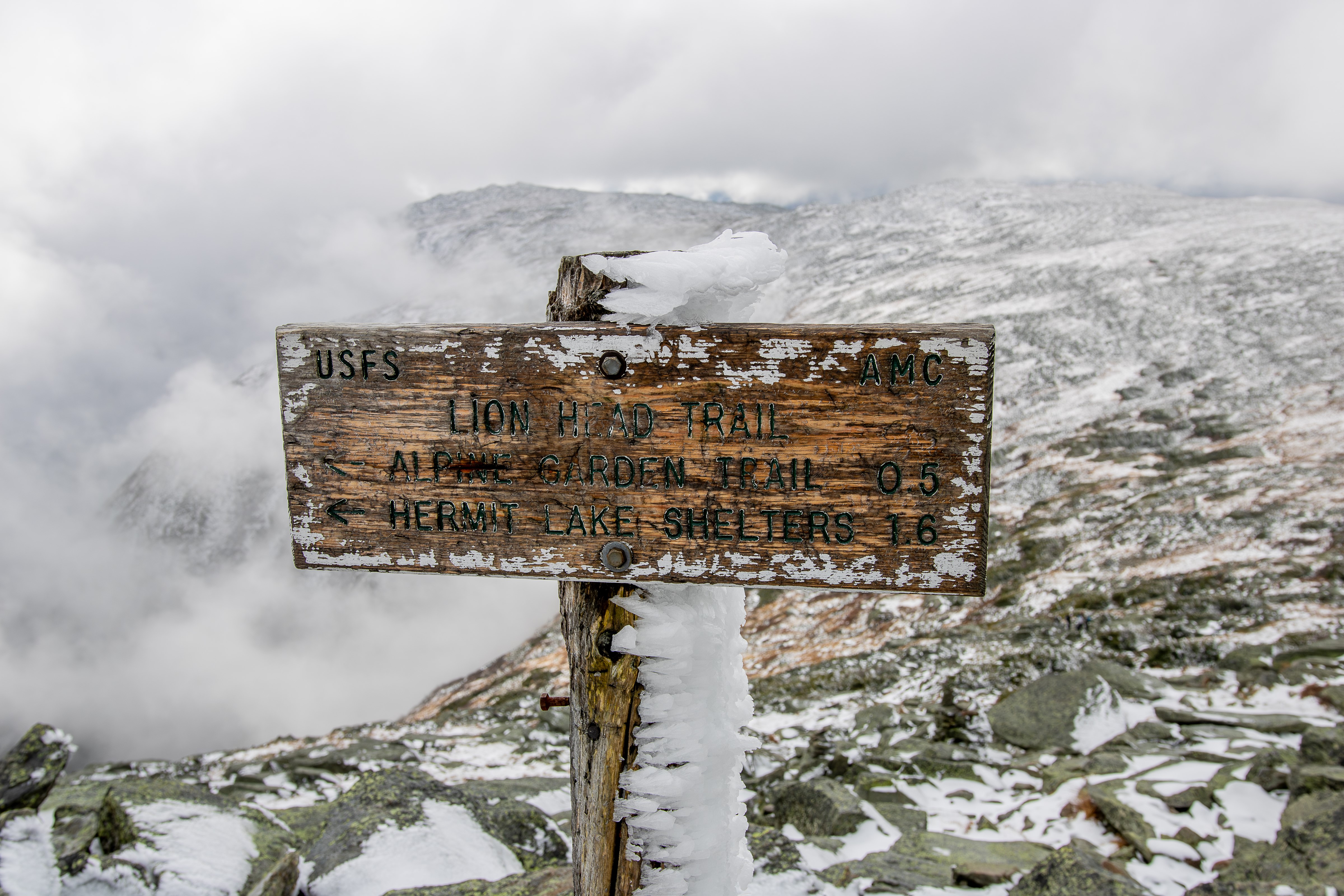 Lion Head Trail sign on Mount Washington covered in rime ice above treeline in winter