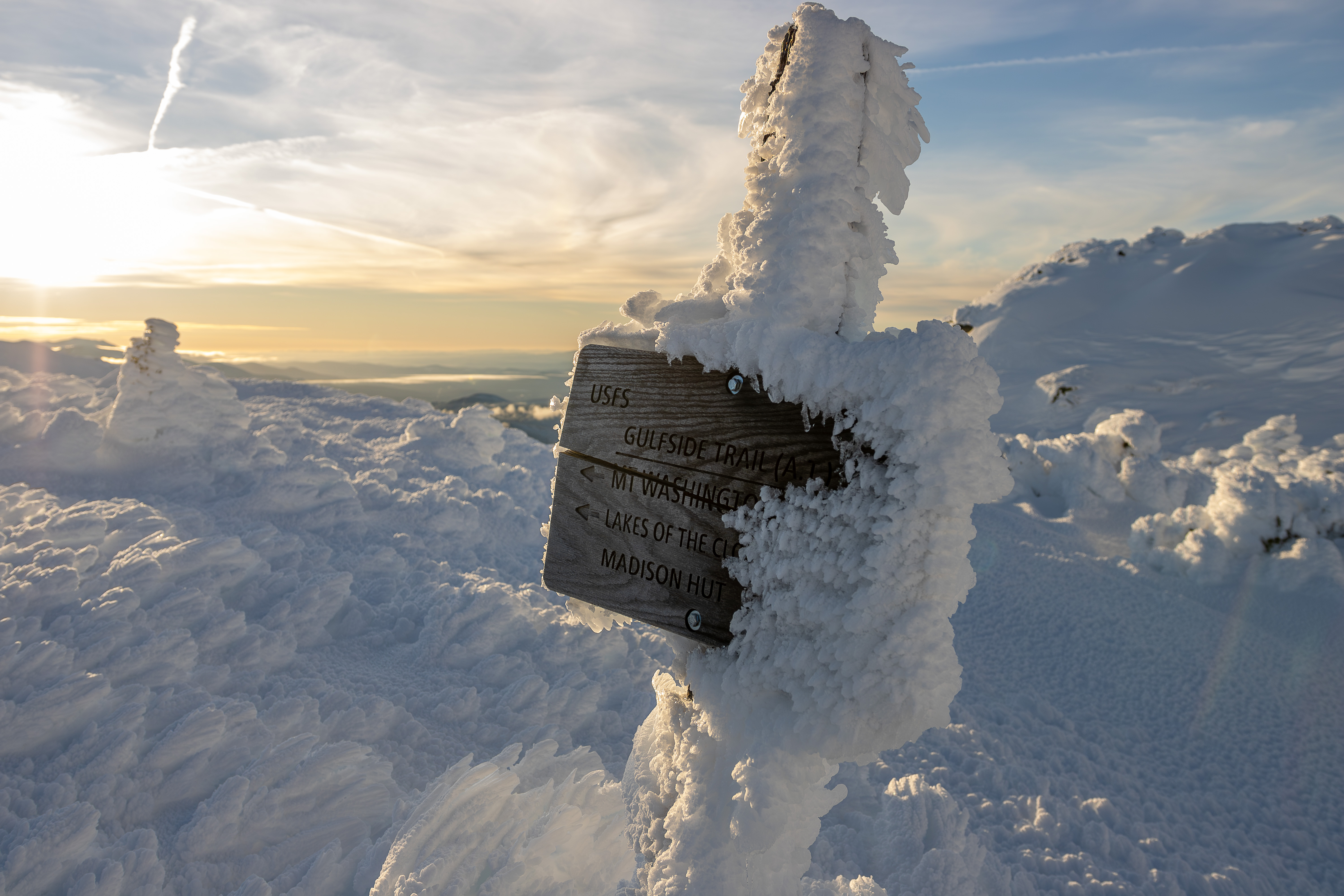 Gulfside Trail sign on Mount Washington covered in rime ice during a winter afternoon in the White Mountains of New Hampshire