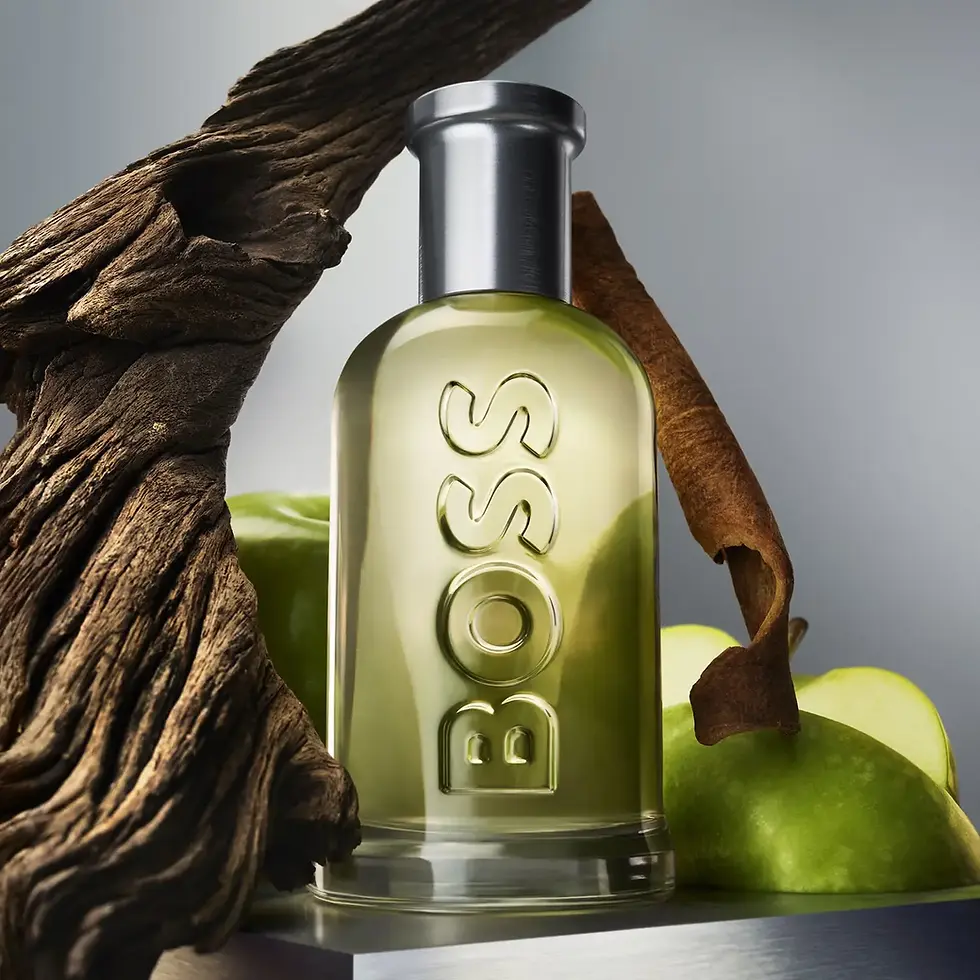 Flacon Boss Bottled entouré de pommes vertes, bois flotté, mise en scène notes olfactives