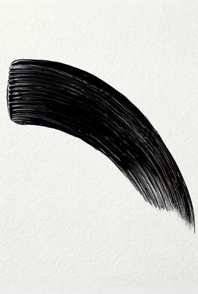Texture mascara noir épais en arc horizontal brillant sur fond blanc texturé, Maybelline Volum' Express
