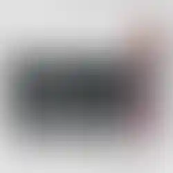 Trousse de maquillage noire à têtes de mort, mascara rouge et khôl noir sur du marbre.