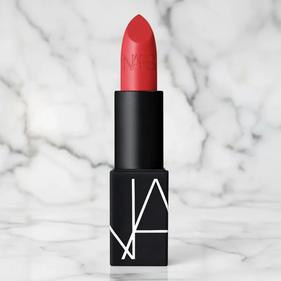 Rouge à lèvres NARS mat couleur rouge intense, tube noir, gros plan sur fond de marbre.