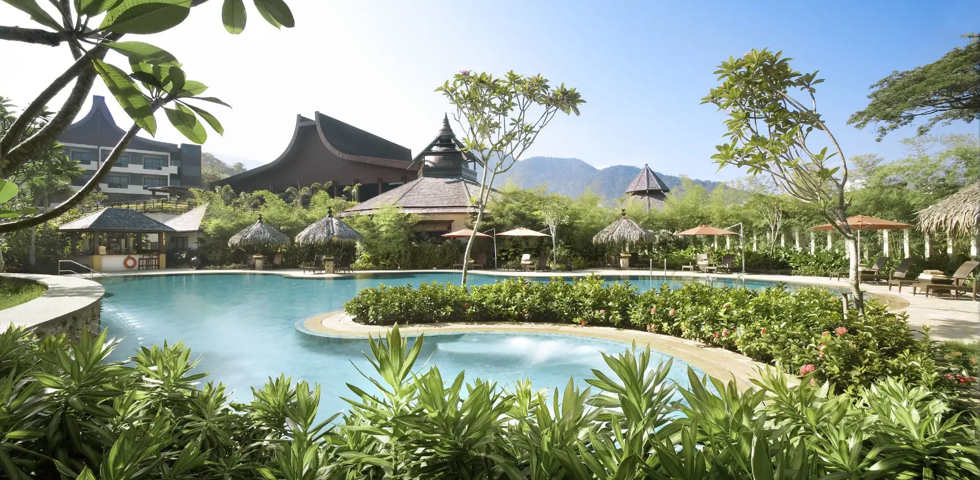 Esterno di un hotel con giardini eleganti e piscina