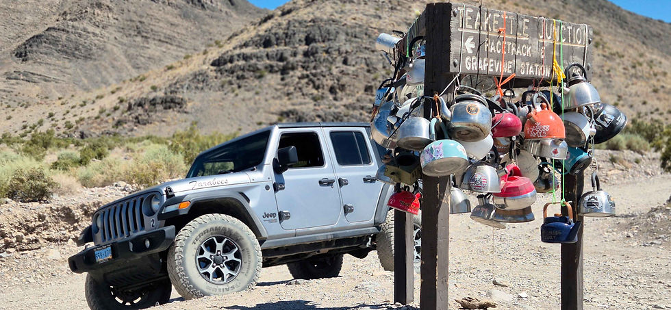 Jeep su strada sterrata e cartello in legno di indicazioni stradali con attaccate molte teiere