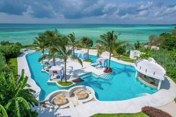 Vista esterna di una piscina con palme, fronte mare