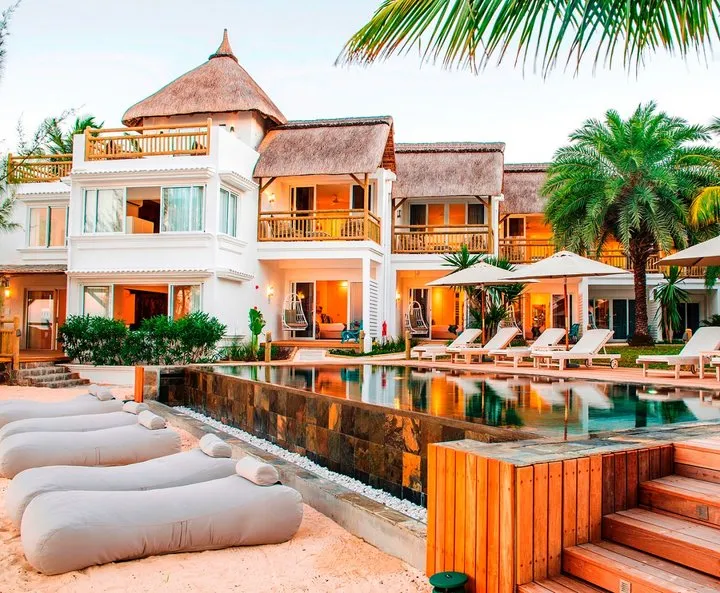 Vista esterna di un hotel con piscina e comode sdraio